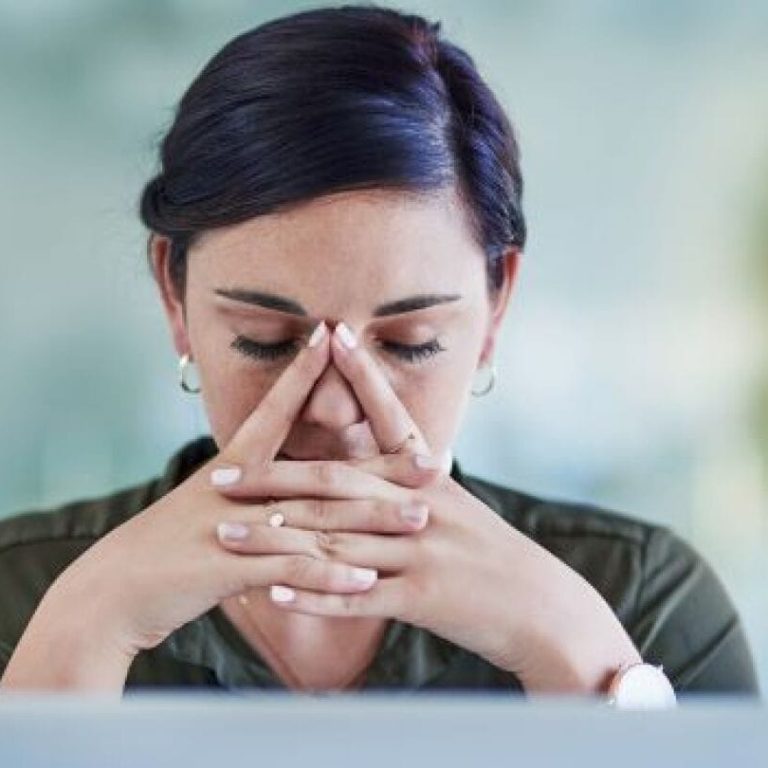 Bir çalışan, işyerindeki stresle başa çıkmak için derin nefes alarak rahatlamaya çalışıyor.